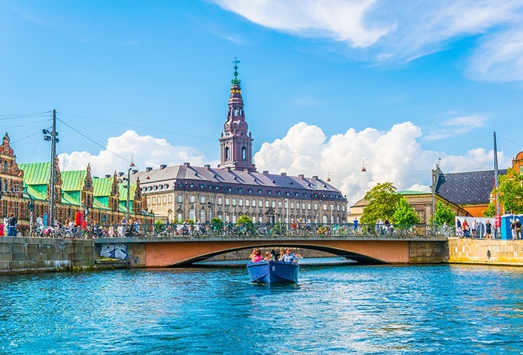 View of church with spire over water in Copenhagen